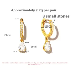 Macro detail of gold pear-cut drop earrings with size specs and micro-set stones