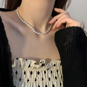 Detail of freshwater pearl necklace worn by a model in a minimalist style