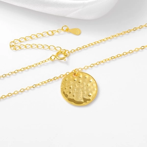 Detail view of gold S925 sterling silver necklace with a hammered round texture pendant
