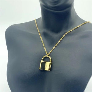 Gros plan du pendentif cadenas en argent S925 plaqué or sur une fine chaîne torsadée