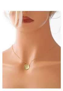 Detail of s925 sterling silver hammered texture round pendant on a gold chain necklace