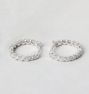 Macro shot of S925 silver twist hoop earrings with clear cubic zirconia inlays