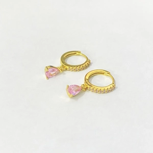 Detailed shot of gold drop earrings with pear-cut pink zircons and micro-pave crystals
