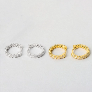 Detail of gold and silver twisted rope huggie earrings with sparkling cubic zirconia inlay