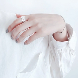 Detail of silver S925 ring with irregular hammered texture and sparkling tennis bracelet