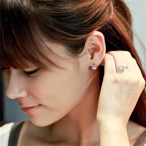 Close-up of minimalist S925 sterling silver four-leaf clover stud earrings and matching ring