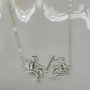 Macro view of S925 sterling silver devil and angel pendant on a fine link chain