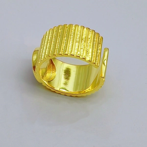 Detailed macro view of wide gold textured ring with vertical pleated pattern and polished finish