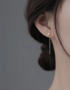 Gros plan de boucles d'oreilles pampilles en argent S925 avec perle naturelle rose portée