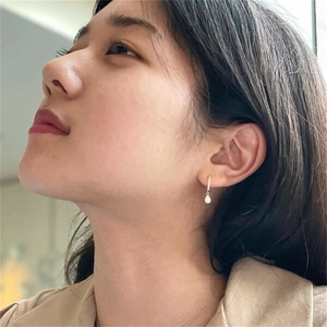 Close-up of elegant S925 silver water-drop zircon earrings worn by a model