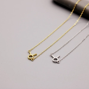 Detailed view of gold and silver Taurus zodiac sign pendants on fine cable chains