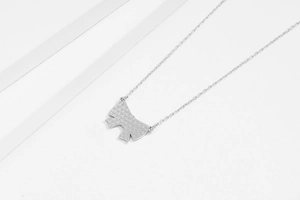 Détail du pendentif nœud en argent S925 avec texture étoilée et chaîne métallique