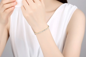 Gros plan d'un bracelet tennis en argent S925 doré avec oxydes de zirconium au poignet