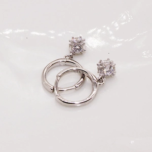 Détail de boucles d'oreilles en argent S925 avec zircon carré montrant le poinçon 925
