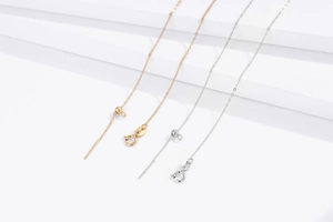 Macro detail of adjustable S925 sterling silver chain with gold and silver bead slide