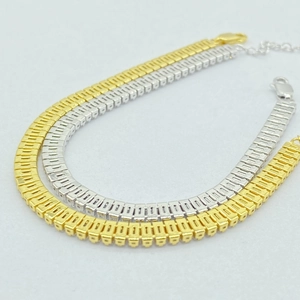 Dettaglio di bracciali tennis con zirconi quadrati in oro e argento e chiusura a moschettone