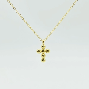 Detail shot of a minimalist 925 silver cross necklace with polished golden bead spheres