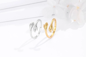 Detailed close-up of S925 silver hugging hands open rings in gold and silver finishes