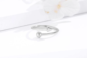 Macro shot of silver minimalist open ring with geometric sphere and arrow details