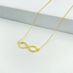 Dettaglio del ciondolo infinito dorato con pietre di zircone bianco micro-pavé