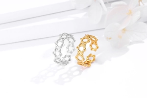 Detail of hollow geometric 925 silver rings in silver and gold on a minimalist stand