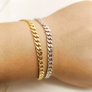 Gros plan de bracelets gourmettes en argent S925 plaqué or et argent sur un poignet