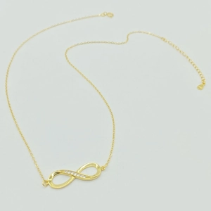 Dettaglio macro della collana infinito in argento sterling S925 dorato con zirconi