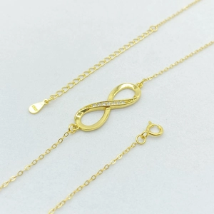 Dettaglio pendente infinito dorato con zirconi su catena in argento sterling S925