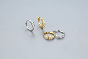 Macro detail of S925 sterling silver huggie hoops with square and round zircon stones