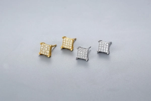 Detailed view of silver and 18K gold square stud earrings with micro-pave crystals