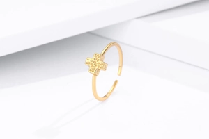 Detail of gold cross ring featuring a fine hammered texture and adjustable open band