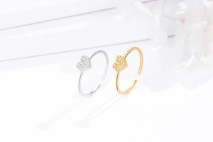Detail of hammered heart-shaped open rings in gold and silver finish with textured surface