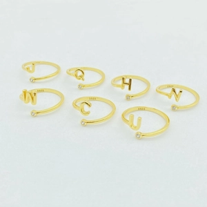 Close-up of S925 sterling silver gold-plated initial rings with zircon and S925 hallmark