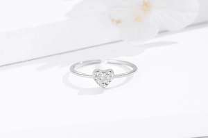Macro shot of silver heart ring with hammered texture and minimalist adjustable band