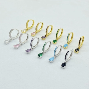 Macro shot of hinged hoop earrings with pear-cut colorful zirconia in gold and silver