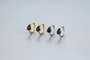 Vue macro de créoles en argent S925 avec pierres noires en forme de goutte et diamants