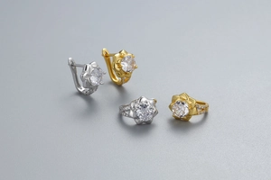 Gros plan sur des boucles d'oreilles fleur en or et argent serties de zircones