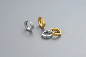 Vue détaillée de boucles d'oreilles créoles en argent S925 avec texture de feuilles ciselées