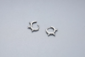 Detail of silver spike hoop earrings with CZ stones in a punk minimalist style
