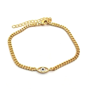 Détail du bracelet gourmette doré avec breloque œil de zircon bleu et fermoir mousqueton