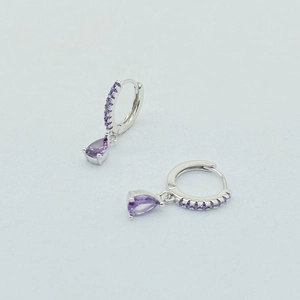 Detail view of S925 silver hoop earrings featuring pear-cut purple gemstones and pavé crystals