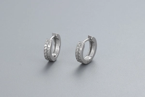 Vue détaillée des boucles d'oreilles huggie en argent S925 avec motifs de feuilles