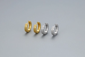 Détail de boucles d'oreilles créoles en argent S925 avec texture de feuille gaufrée