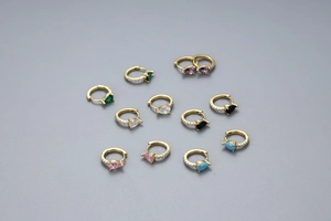 Détail de créoles en argent S925 doré avec des zircons colorés en forme de goutte