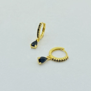 Detail of gold drop earrings with black pear-cut stones and crystal pavé accents