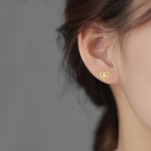 Macro shot of s925 silver hollow heart stud earrings with sparkling round zircon