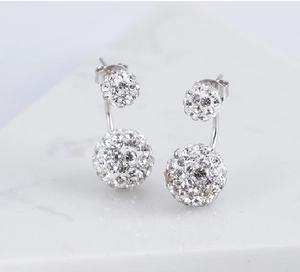 Dettaglio di orecchini a doppia sfera in argento S925 con pavé di cristalli lucenti