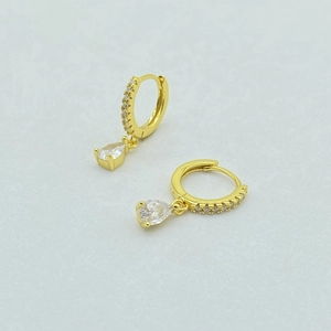 Macro detail of gold pear-shaped drop earrings with micro-paved cubic zirconia stones