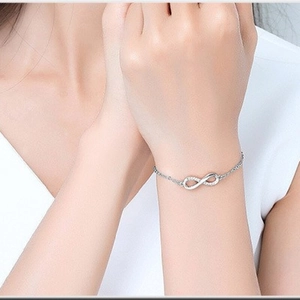 Detail of S925 sterling silver infinity bracelet with pavé cubic zirconia on model wrist