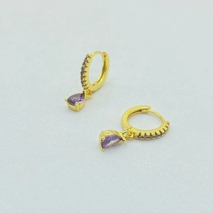 Close-up of gold hoop earrings with pavé purple crystals and pear-cut drop stones